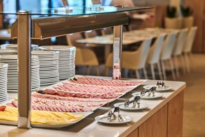 Un bufé con diferentes carnes y quesos.