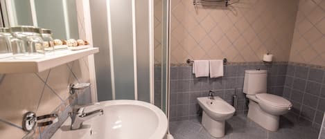 A modern bathroom with a large sink, a bidet, and a toilet.