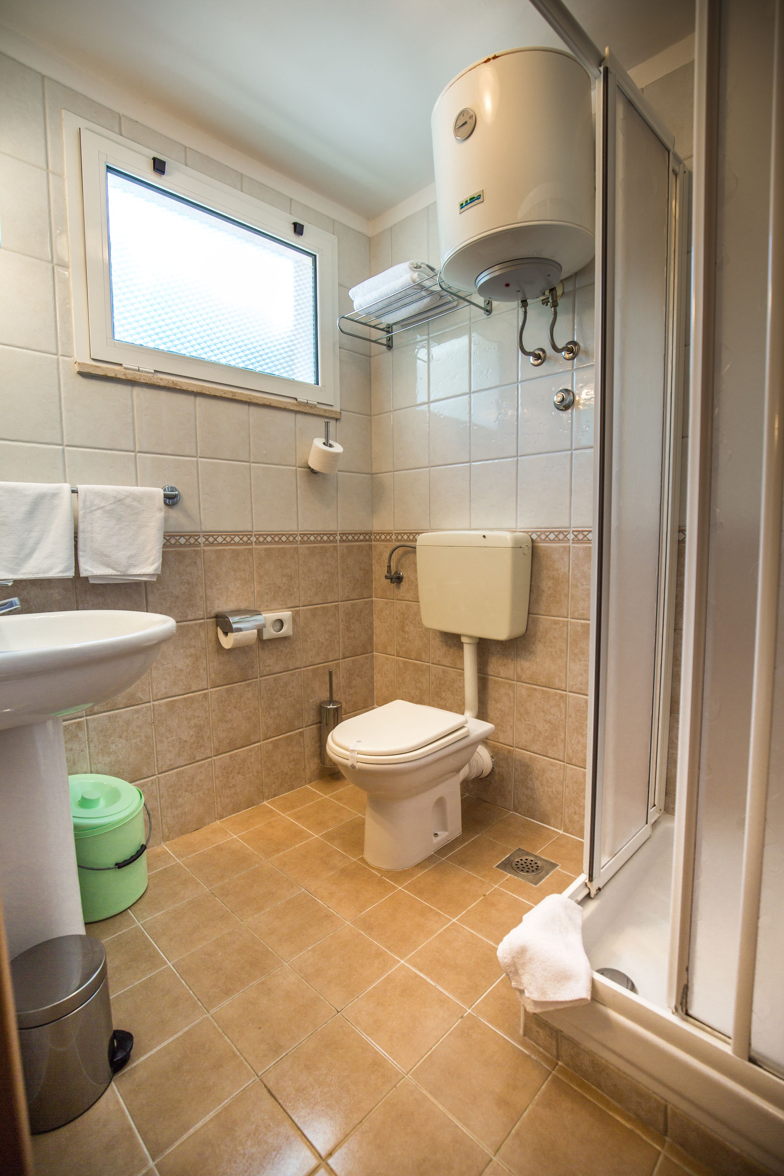 A bathroom with a toilet, sink, and shower.