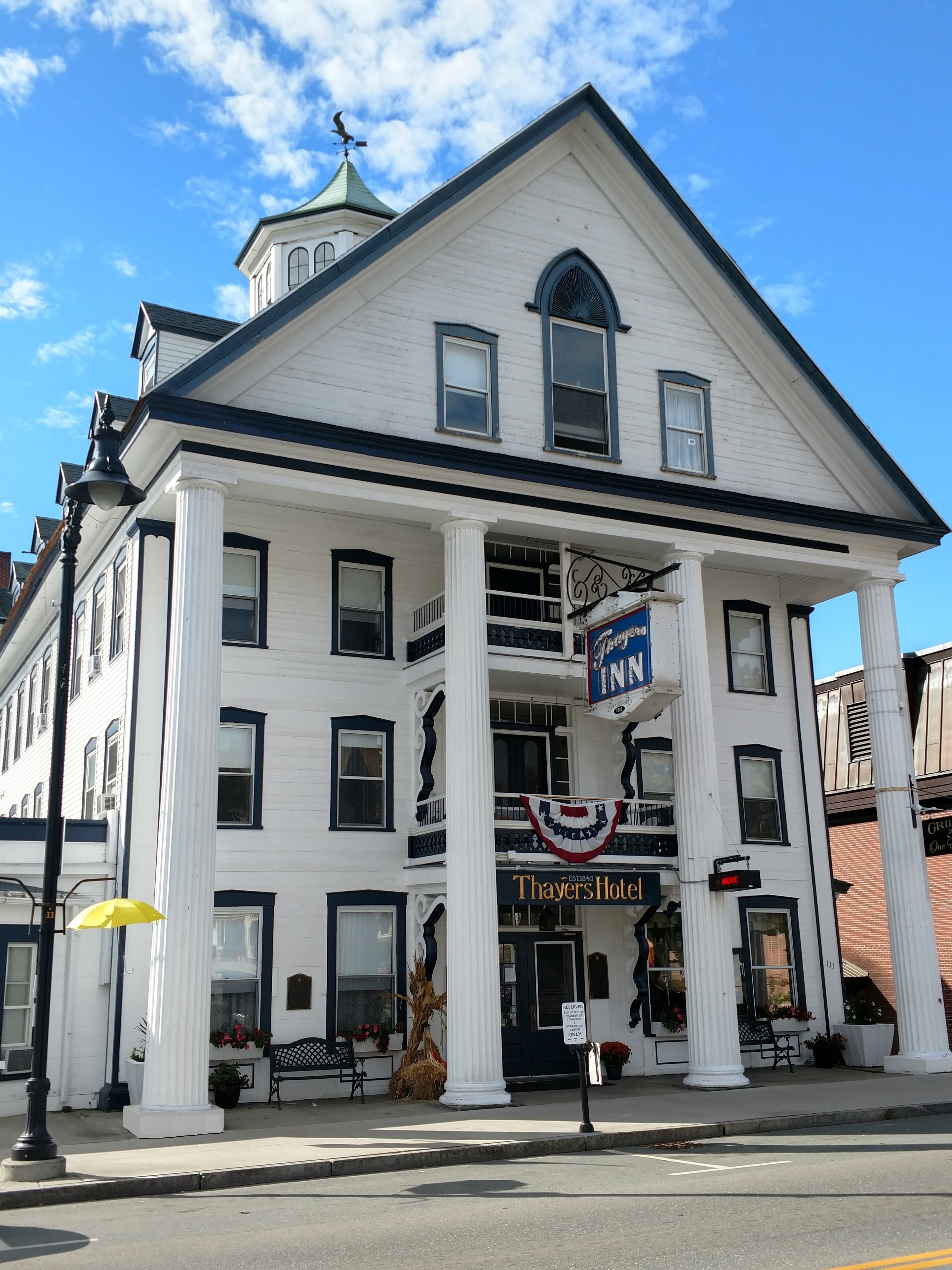 Un bâtiment blanc avec une enseigne indiquant « Thayers Hotel » et « Griffin Inn ».