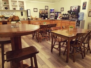 A hotel kitchen with wooden furniture, a coffee machine, and a water dispenser.