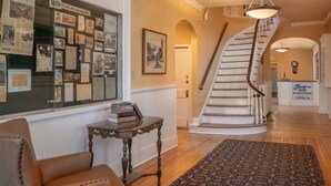 Una posada histórica con una escalera espiral, una exhibición de documentos históricos y una zona de recepción.