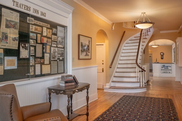 A historic inn with a spiral staircase, a display of historical documents, and a reception area.