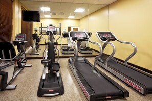 A gym with treadmills, elliptical machines, and a stationary bike.