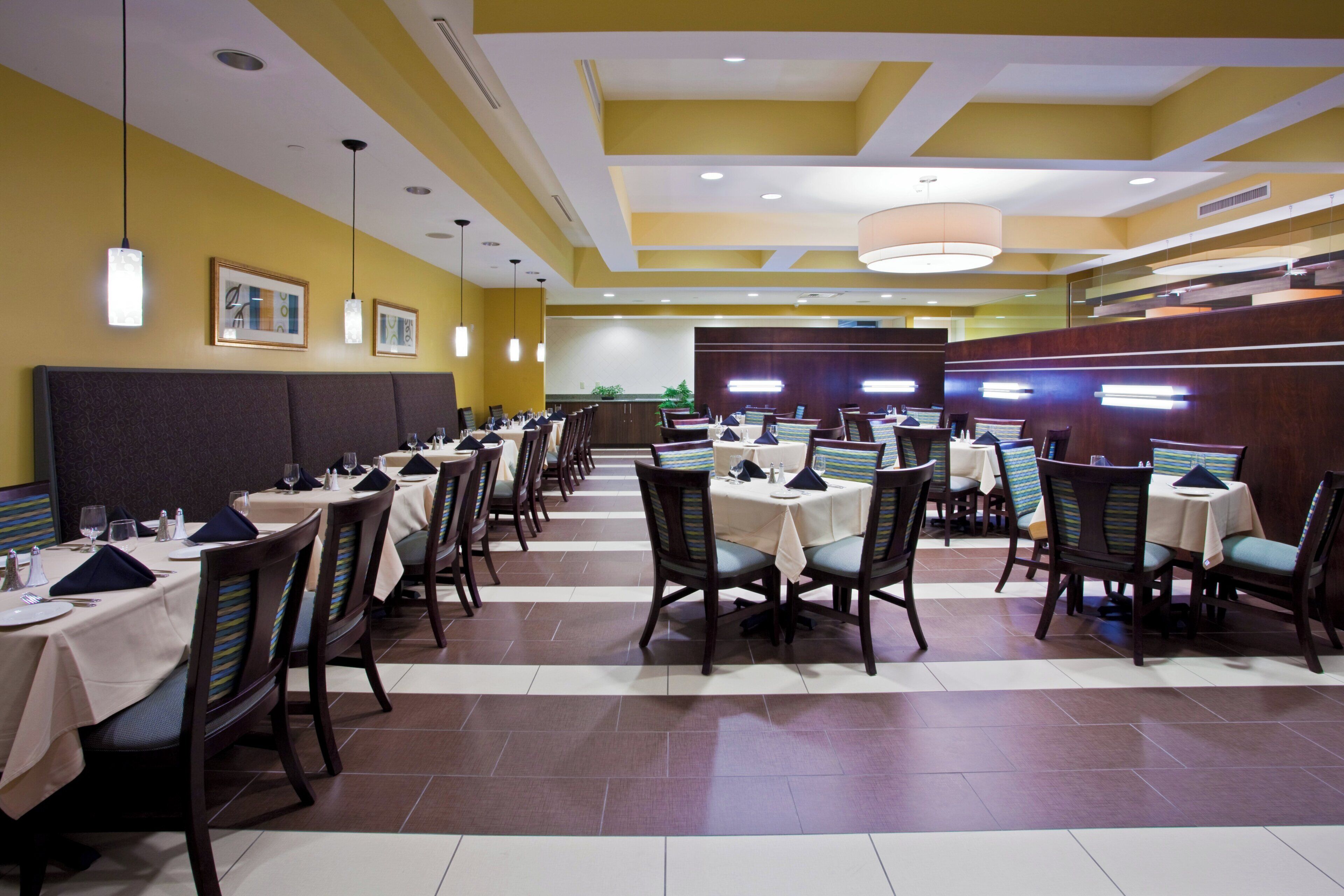 A restaurant with multiple tables and chairs, arranged in a spacious layout.