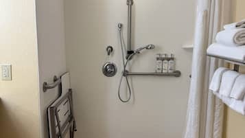 A small, tiled shower area with a grab bar, a towel rack, and a showerhead.