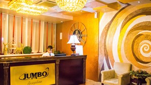 A reception area with a large chandelier, a clock, and a reception desk labeled "Jumbo Reception". - Jumbo Hotel (Chisinau)