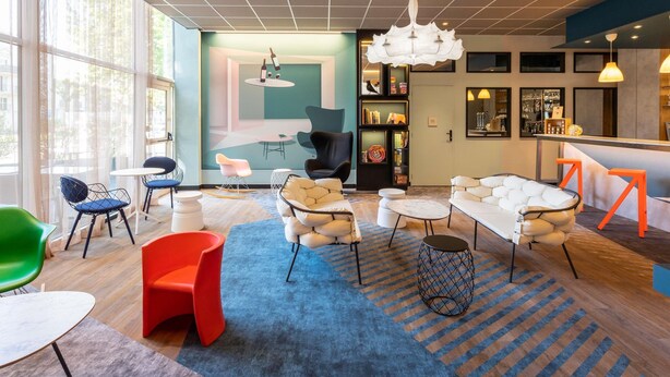 A modern lounge area with a bar, seating arrangements, and a large window providing natural light. - ibis Styles Bordeaux Meriadeck (Bordeaux)