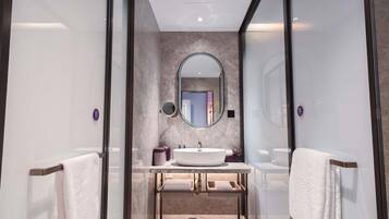 A modern bathroom with a large mirror, two sinks, and a vanity.
