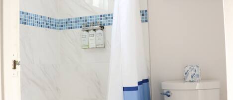 A bathroom with a shower, toilet, and towel rack.