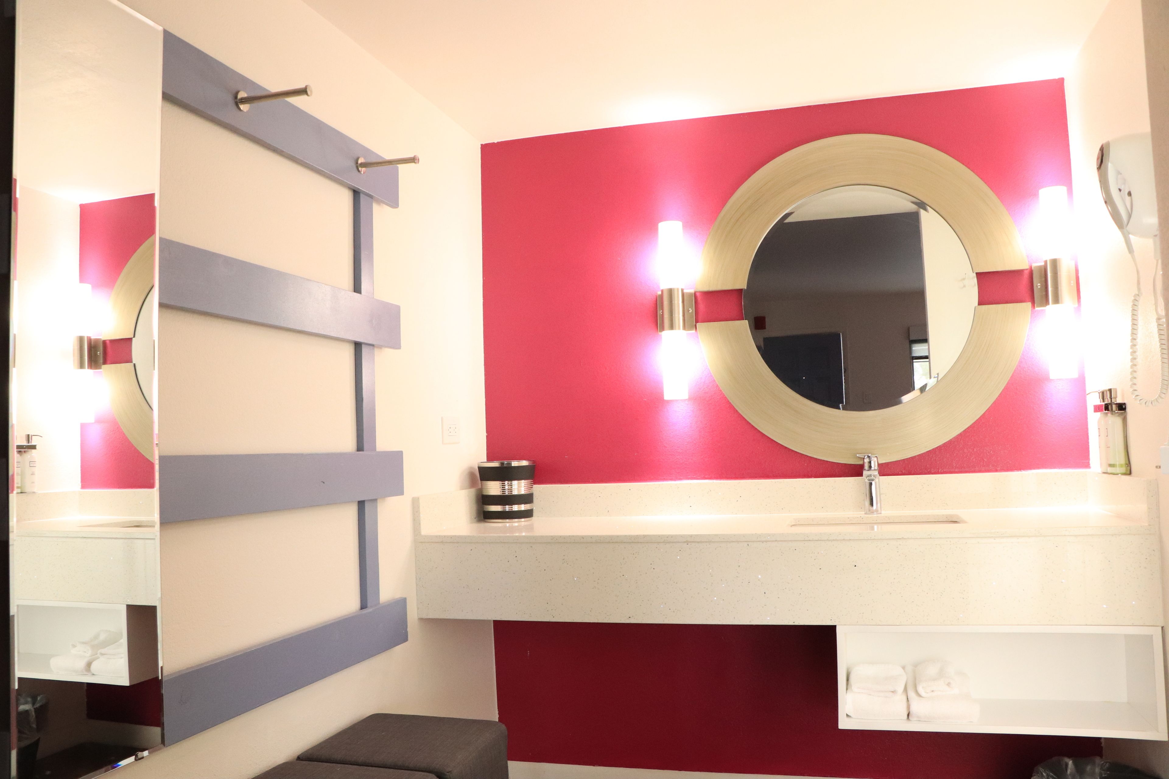 A bathroom with a mirror, sink, and towel rack.