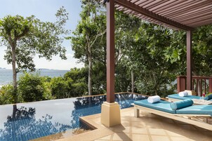 Una piscina infinita con sillones de descanso y vistas al mar.