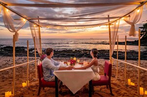Una pareja cenando en una mesa frente al mar.
