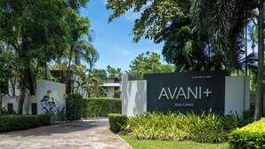 Un panneau indiquant l’hôtel AVANI+ Koh Lanta, avec un chemin menant à l’entrée.