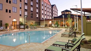 A hotel with a swimming pool, outdoor seating, and a sign for Hilton Garden Inn. - Hilton Garden Inn Pensacola Airport - Medical Center (Pensacola)