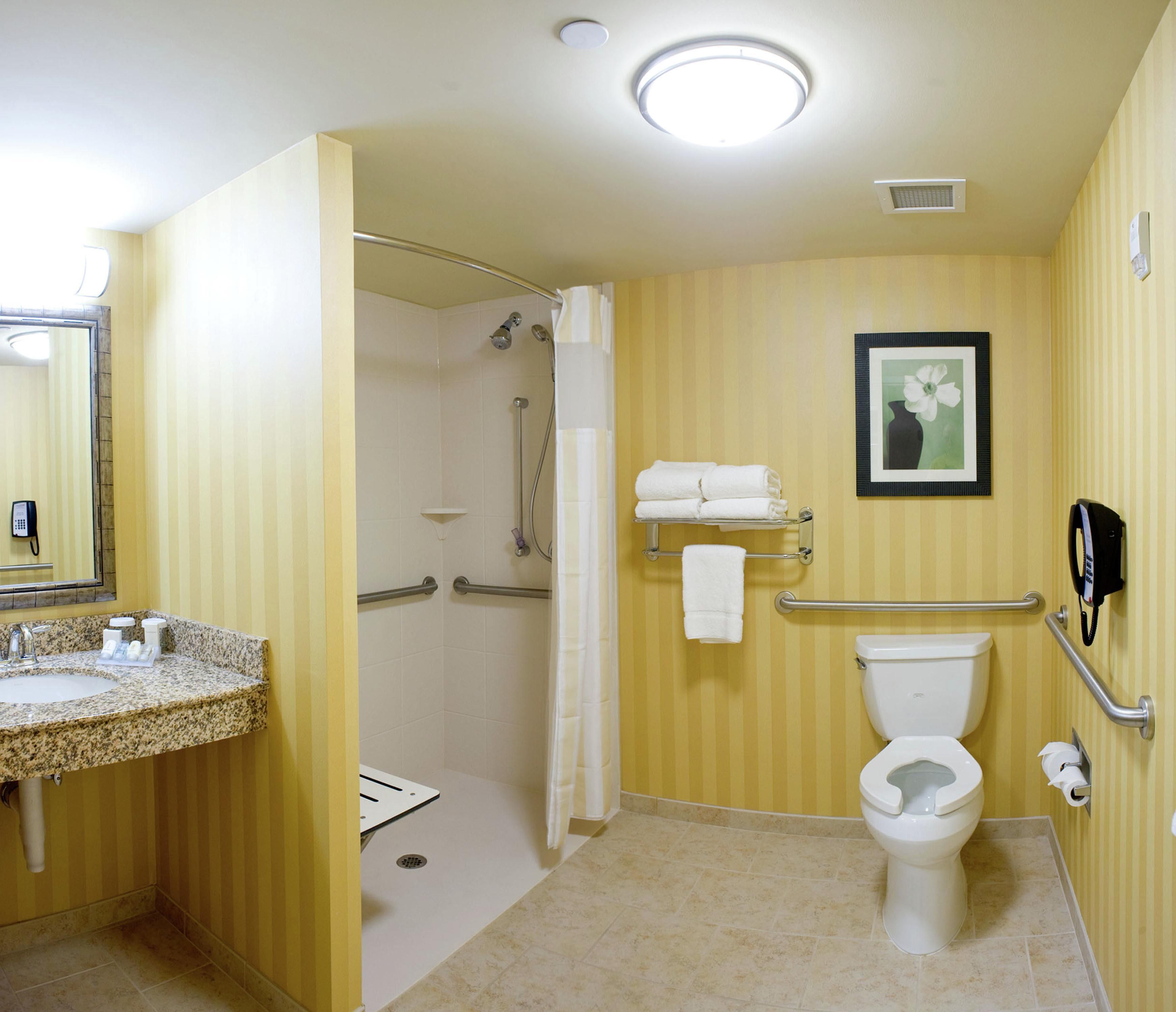 Une salle de bain avec douche, toilettes et lavabo.