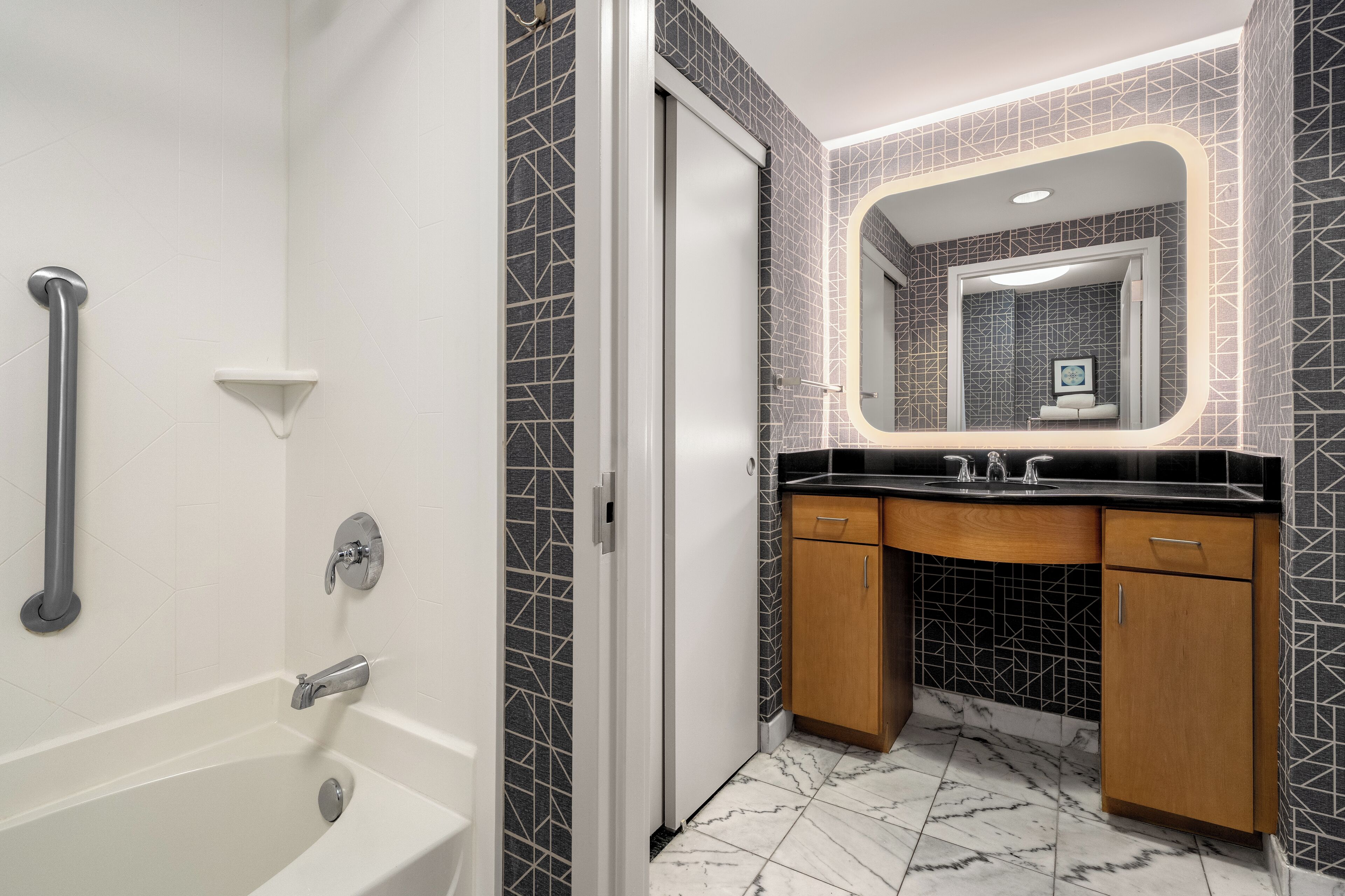 Un baño moderno con bañera, cabina de ducha, tocador con espejo y lavabo.