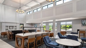 Un comedor amplio con techos altos, ventanas grandes y muebles modernos.