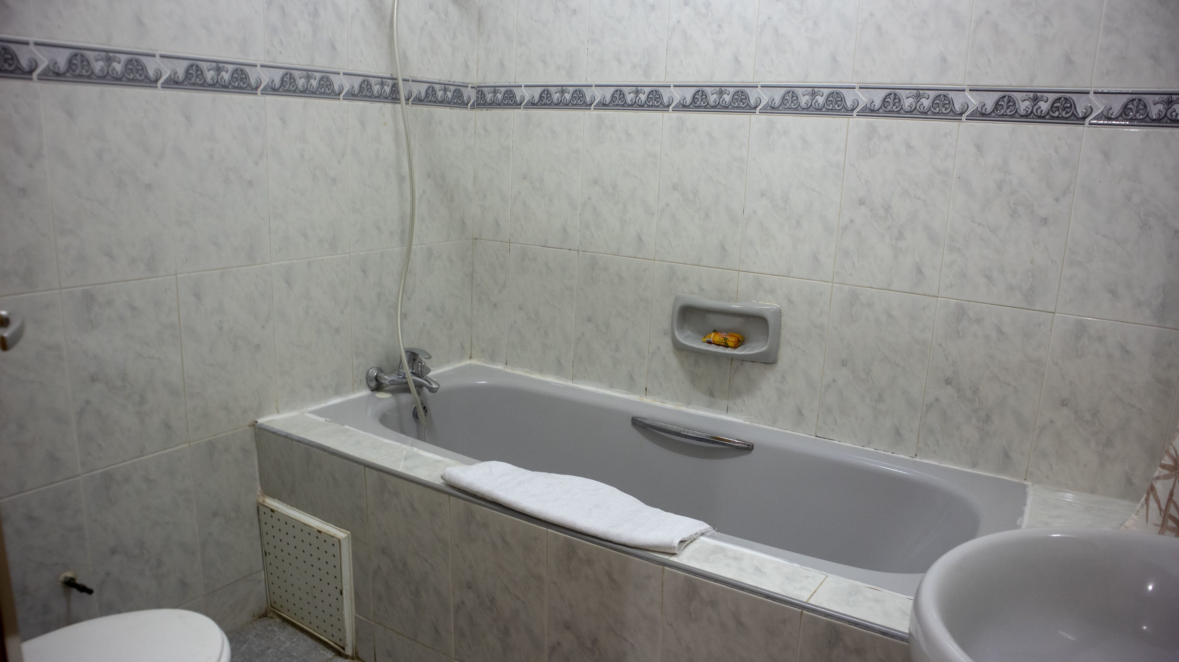 A bathroom with a bathtub, a toilet, and a shower area.