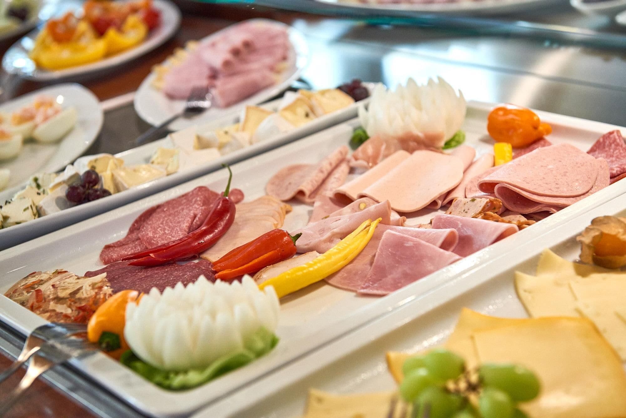 Um buffet com diversos tipos de carne e queijo.