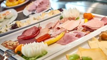 Um buffet com diversos tipos de carne e queijo.