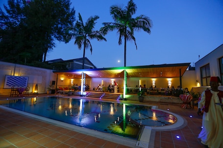 Una piscina al aire libre, sillones reclinables de piscina