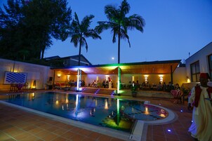 Una piscina al aire libre, sillones reclinables de piscina