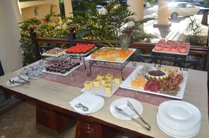 Una mesa de buffet con diversos alimentos y utensilios.
