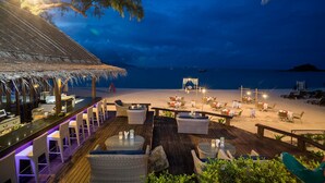 A beachside restaurant with outdoor seating, a bar, and a view of the ocean. - Royal Muang Samui Villas (Koh Samui)