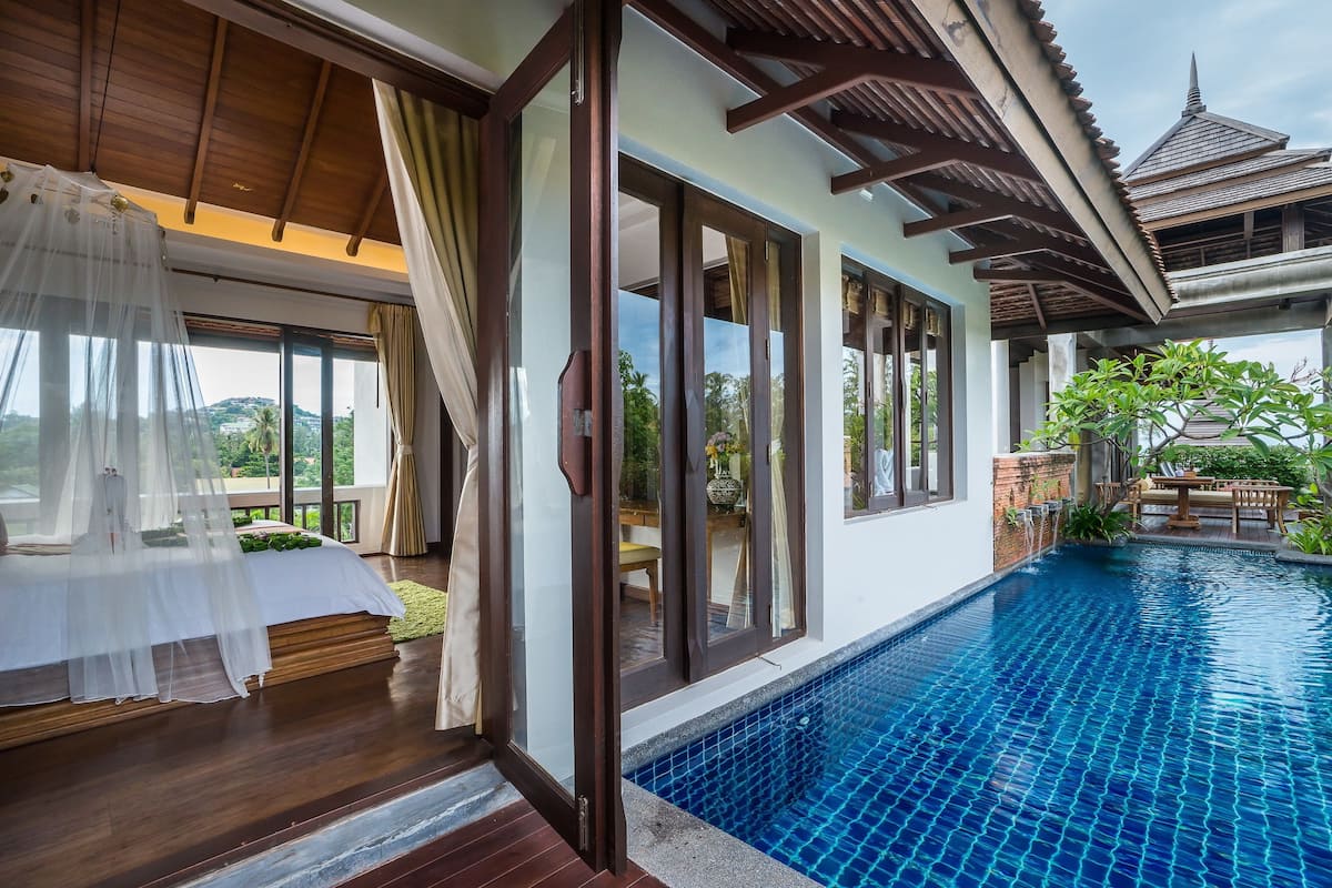 Quarto de hotel moderno com uma janela grande, varanda privativa e piscina.