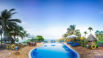 Een buitenzwembad, parasols voor strand/zwembad