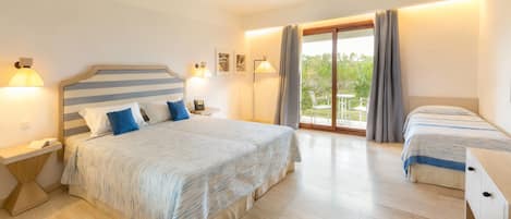 A hotel room with a large bed, a smaller bed, a desk, and a balcony with curtains.