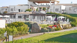A resort with outdoor seating, a covered area, and a landscaped garden. - Resort Grande Baia (San Teodoro)
