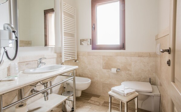 Un baño moderno con lavamanos, inodoro y bidé.