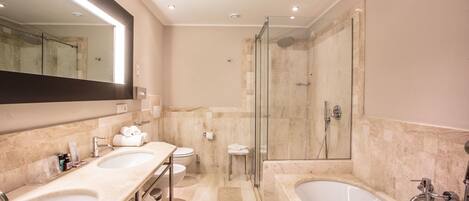 A modern bathroom with two sinks, a toilet, a shower, and a bathtub.