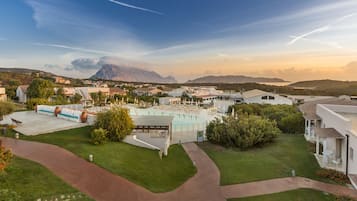 Alberca al aire libre, sombrillas en la alberca y camastros
