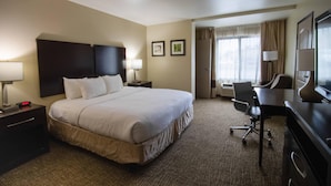 A hotel room with a bed, bedside tables, a desk, and a chair. - Comfort Inn & Suites San Bernardino (Colton)