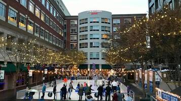 A Courtyard by Marriott hotel with a central courtyard featuring an ice rink, surrounded by trees decorated with lights.