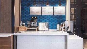 A modern kitchen with a marble countertop, a coffee machine, and a menu board.
