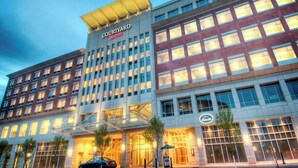 A Courtyard Marriott hotel with a modern design, featuring a prominent entrance with glass doors and a covered walkway. - Courtyard by Marriott Greenville Downtown (Greenville)