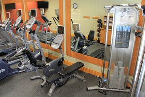 A gym with various exercise machines, including treadmills and weight machines, arranged in rows. - Hilton Garden Inn Houston West Katy (Katy)