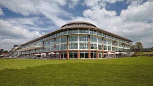 Un edificio moderno con fachada curva, ventanas amplias y techo plano.