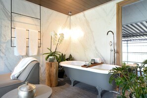 A modern bathroom with a freestanding bathtub, marble walls, and a wooden ceiling. - Brick Hotel - Small Luxury Hotels of the World (Mexico City)