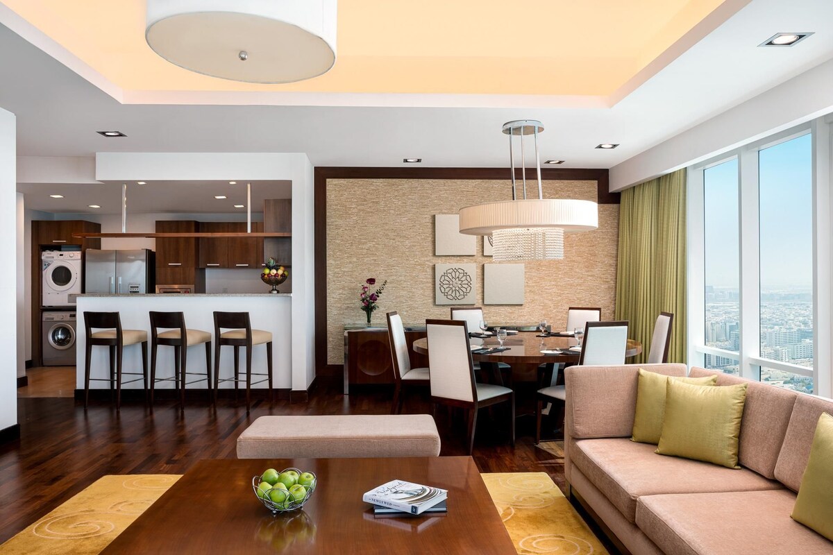 A modern living room with a sofa, coffee table, and dining area.