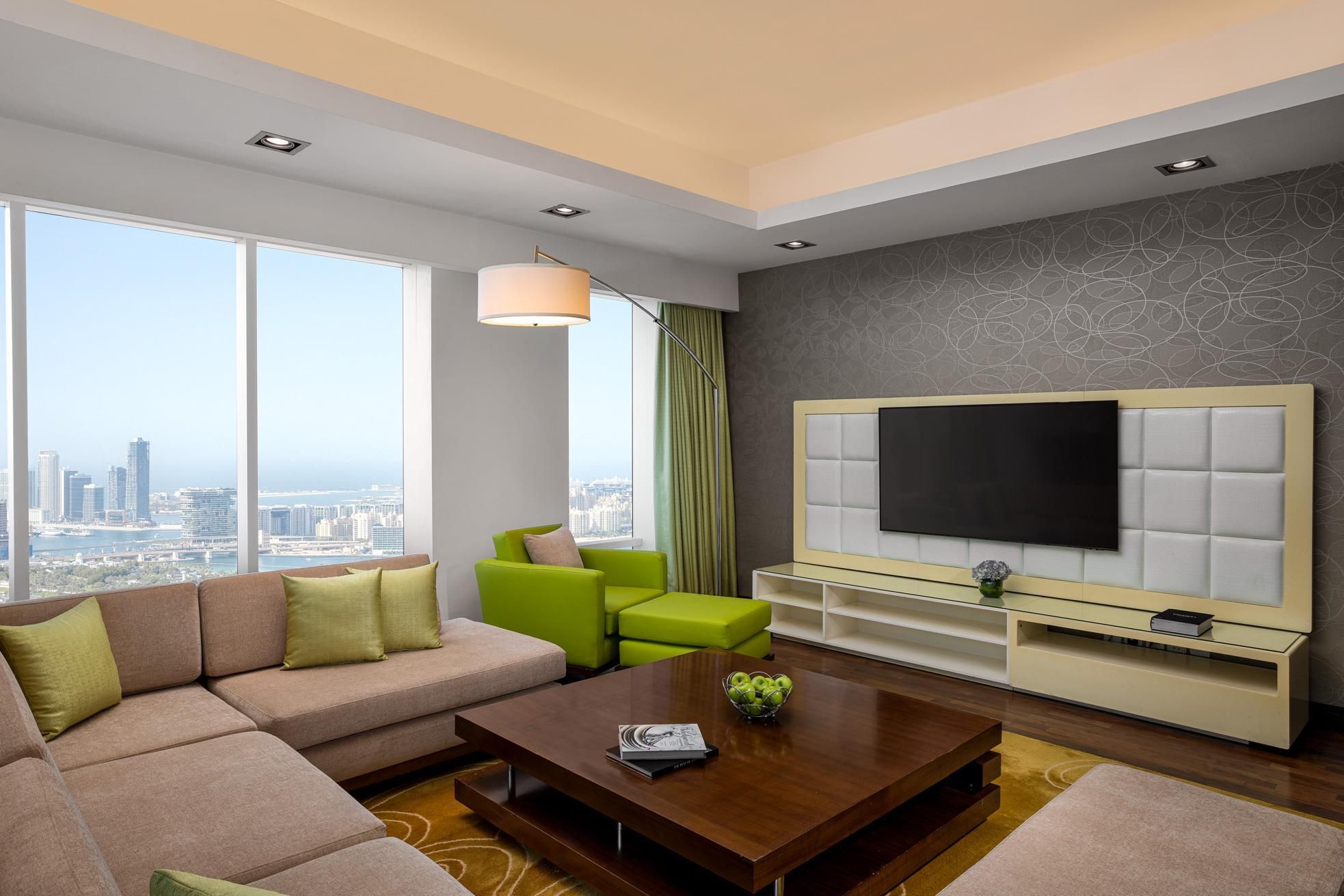A modern living room with a sofa, coffee table, and a TV on a built-in unit.