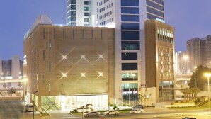 A high-rise building with multiple floors, large windows, and a modern architectural design. - La Suite Dubai Hotel & Apartments Operated by Minor Hotels (Dubai)