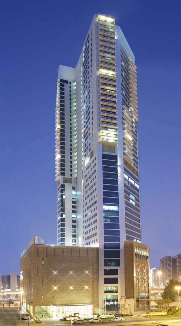 A high-rise building with multiple floors, large windows, and a modern architectural design. - La Suite Dubai Hotel & Apartments Operated by Minor Hotels (Dubai)