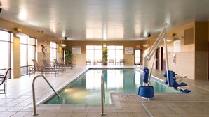 An indoor swimming pool with a lifeguard chair, lounge chairs, and a pool ladder. - Hampton Inn & Suites Vineland (Vineland)