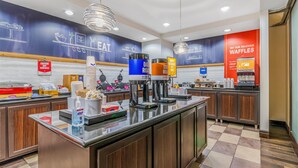 Un café moderne doté d’un espace où l’on peut se servir soi-même son café, d’un coin dédié aux gaufres et d’une affiche faisant la promotion de ces dernières.