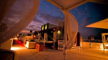 Una piscina al aire libre, sombrillas, sillones reclinables de piscina